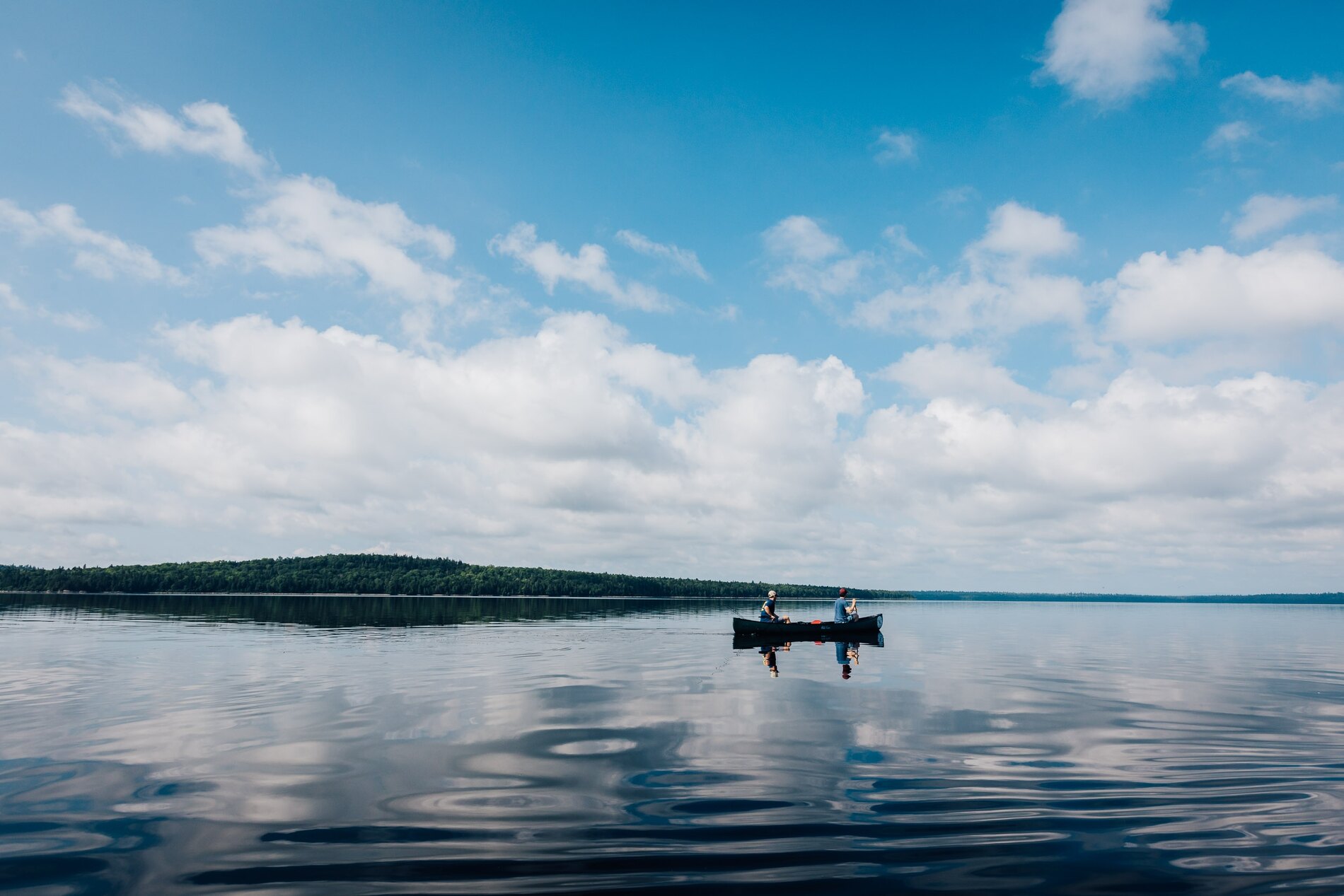 Two people in a canoe on a lake in the Allagash Wilderness Waterway
