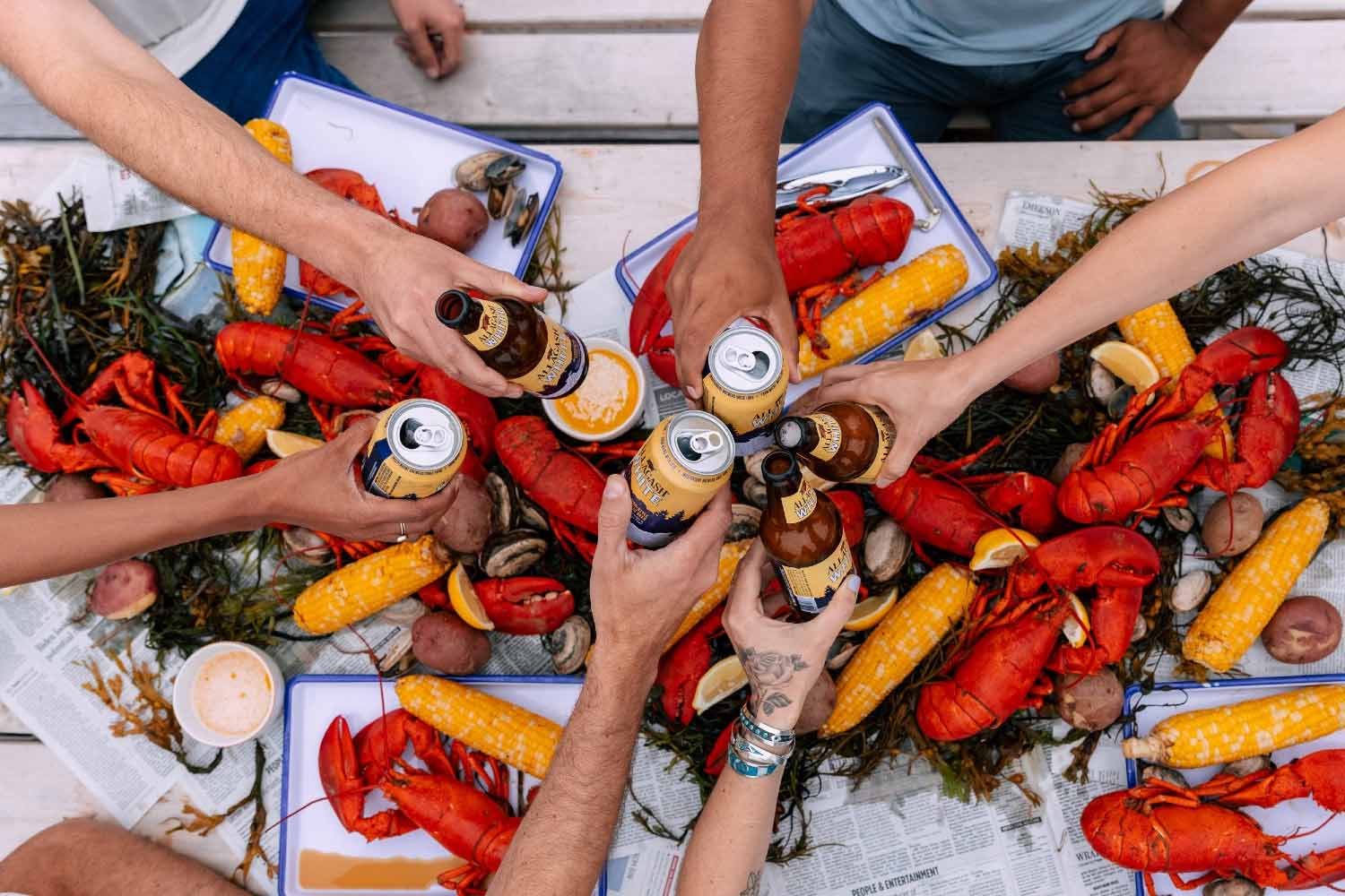 Friends, beer, and a whole lot of lobster viewed at a picnic table