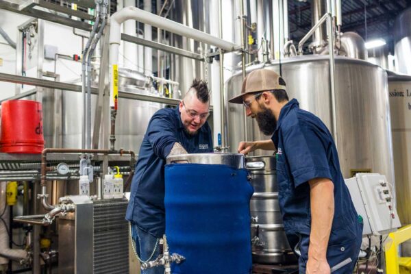 Two members of the Allagash team brew a pilot beer: a smoked saison.