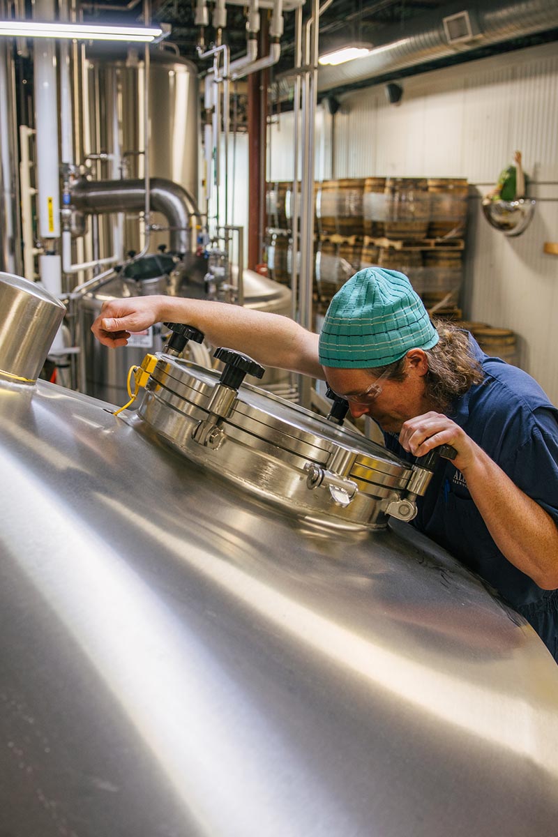 brewer looking into a brewing vessel