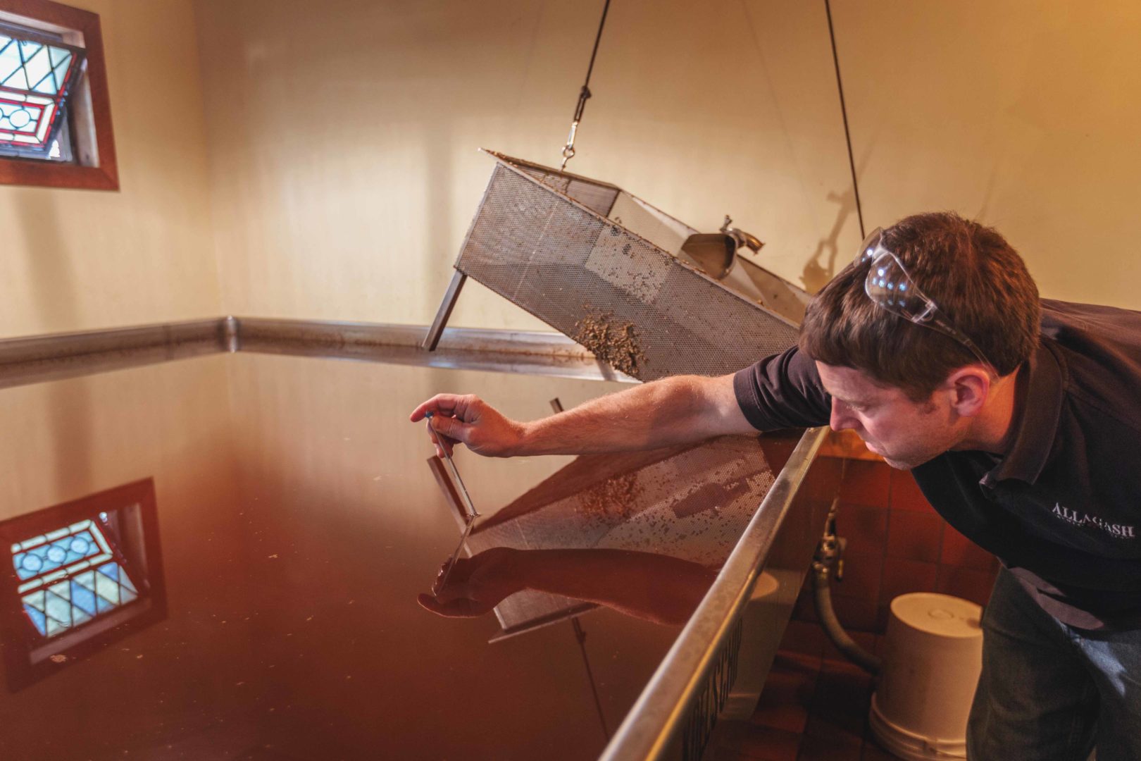 Allagash Brewmaster Jason Perkins takes the temperature of a batch of Coolship wort.
