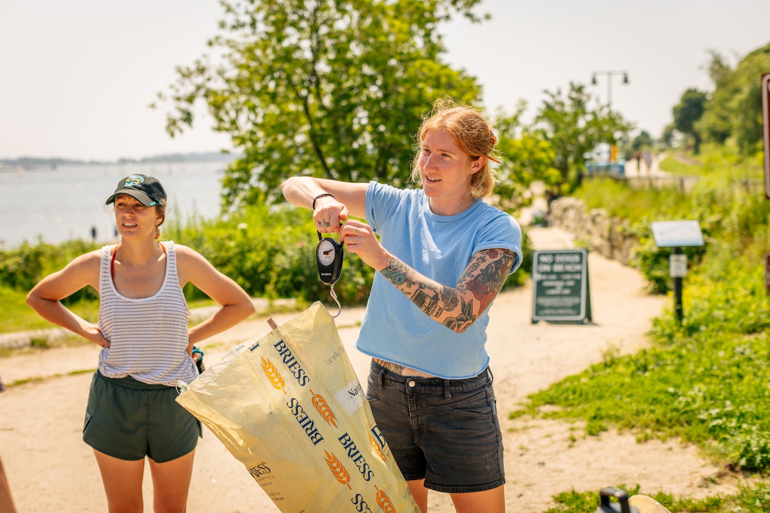 weighing trash that the Allagash team picked up during a cleanup of East End Beach
