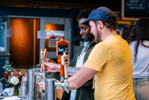 Two Allagash employees grab a beer during a company party