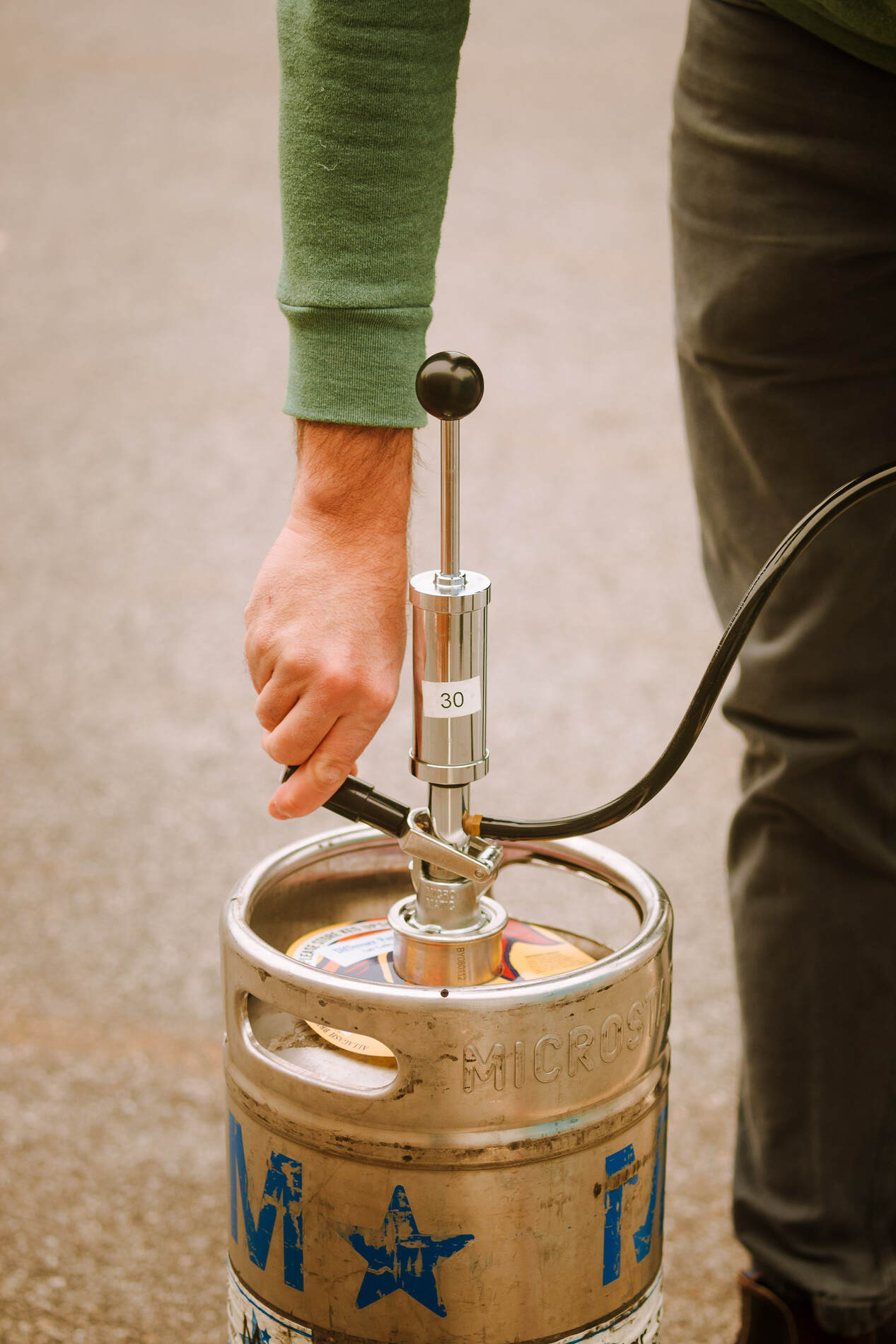 Demo on tapping a keg. STEP 2: Line up the bottom of the tap with the mouth of the keg.