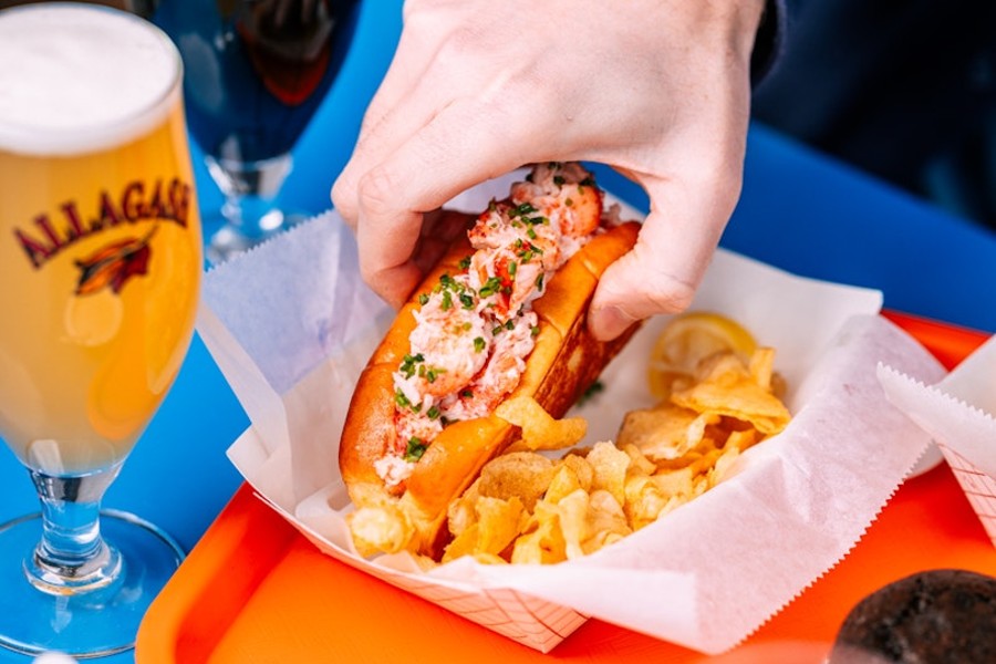 This lucky person is about to enjoy a big bite of lobster roll, followed by a sip of Allagash White