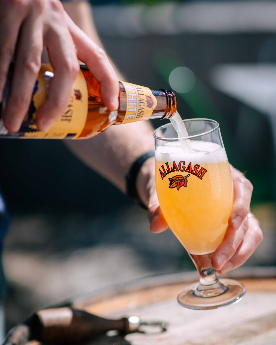 Pouring Allagash White into a chalice from a roused bottle of beer