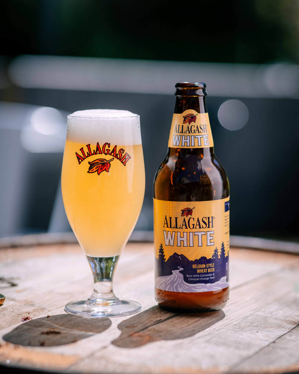 A perfectly rouse chalice of Allagash White sitting next to a proud bottle