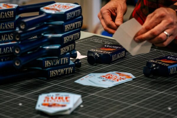 People putting stickers on tap handles for Allagash Surf House