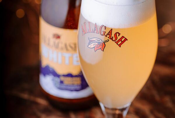 Allagash White in a chalice and 12 oz. bottle on a table